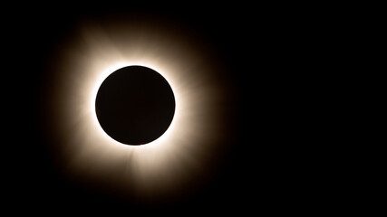 Beautiful photo of a total solar eclipse at totality with the sunshine shooting out from behind the...