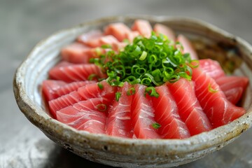 Traditional sashimi bowl filled with thinly sliced tuna, garnished with green onions, showcasing Japanese culinary artistry.