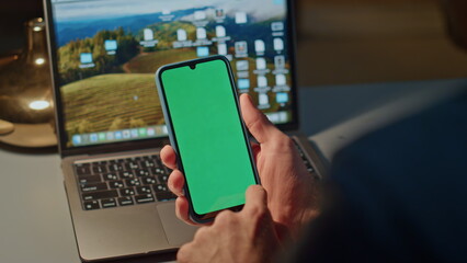 Man finger touching green phone screen indoor closeup. Guy scrolling smartphone