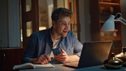 Smiling student videocalling computer at evening workplace closeup. Man talking