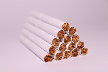 a group of white cigarettes with gold tobacco in the shape of a pyramid on a white background