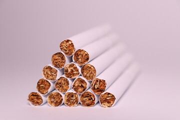 a group of white cigarettes with gold tobacco in the shape of a pyramid on a white background