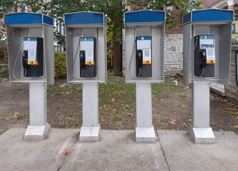 Four coin operated pay phones in a row