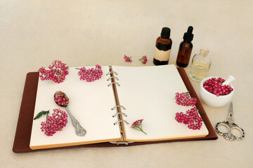 Achillea yarrow herb flower preparation. Alternative natural herbal medicine with notebook, tincture and oil bottles and mortar. Treats hemorrhoids, wounds, bloating, flatulence. On hemp paper. - 782455432