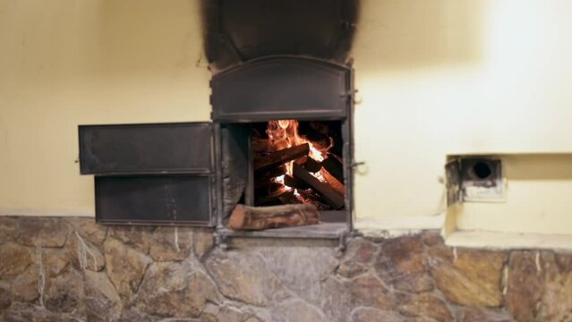 Artisanal oven with fire inside. Oven for pizza and bread on rustic stone wall.