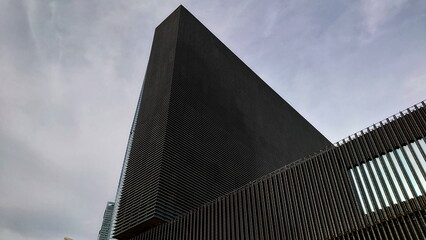 Hong Kong - 08.29.2021: Close-up of the exterior of Mplus museum under a cloudy grey sky during the...