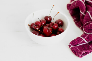 Cherries on a bowl, on white background. Minimalist composition.