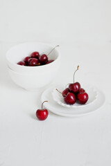 Cherries on a bowl, on white background. Minimalist composition.