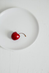 Cherries on a bowl, on white background. Minimalist composition.