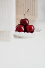 Cherries on a bowl, on white background. Minimalist composition.