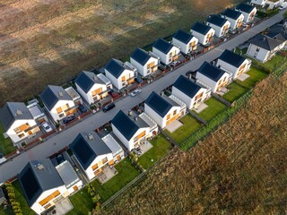 A modern housing estate consisting of rows of houses, a bird's eye view during sunrise,...