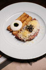 tartare on a white plate, gourmet dish in a restaurant