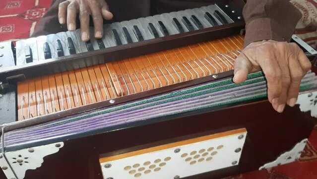 A Man Playing Harmonium. Closeup shot of hands of a Man playing Harmonium. Traditional world. Folk instrument. Pakistani man playing harmonium in the house. Beautiful 4K Footage.