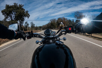 Riding a black motorbike on an asphalt road rider point of view with shining mirrors