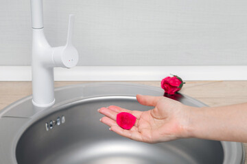 man washes his hands with soap rose petals.