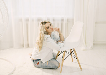 Woman Sitting Next to White Chair