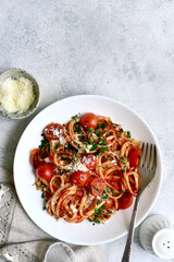 Traditional italian pasta with grilled tomatoes, parmesan and garlic. Top view with copy space.