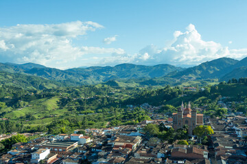 Fototapeta na wymiar Wide panorama of the superb village (pueblo) of Jerico, Jericó Antioquia, Colombia, with a blue sky and the majestic Andes Mountains in the background. Picture taken from El Morro El Salvador.