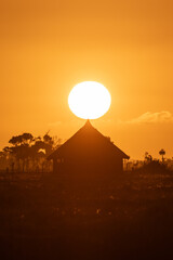 Sunset in the countryside with silhouette of wooden huts