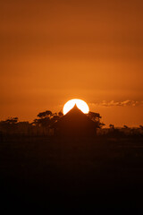 Sunset in the countryside with silhouette of wooden huts