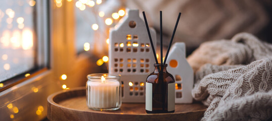Banner. Cozy home decor, hygge and aromatherapy concept. Aroma diffuser, burning candle, Christmas...