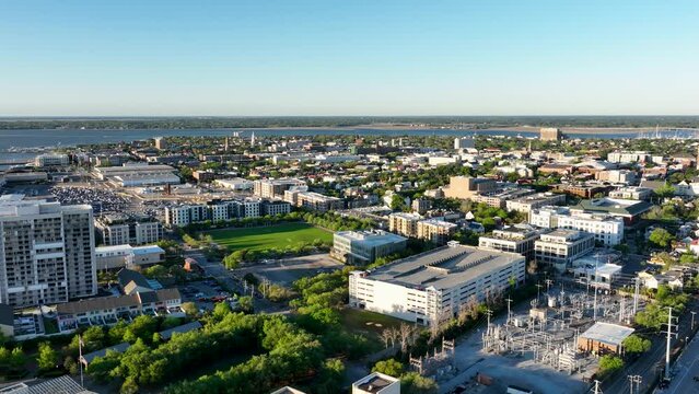 Sunrise over Downtown Charleston, SC, with historic district aerial view, highlighting vibrant rooftops and streets.