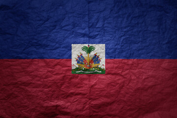 big national flag of haiti on a grunge old paper texture background