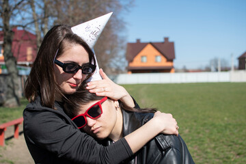 Portrait of a two young women in sunglasses and hats for a birthday party	