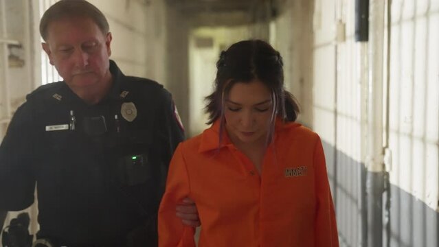 Female Woman Prisoner in Orange Jumpsuit Jail Prison with Police Officer
