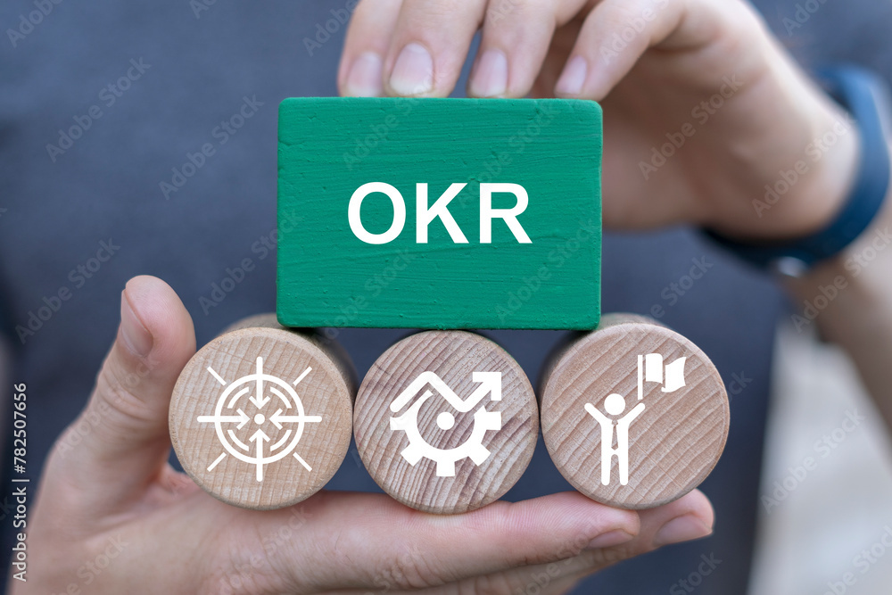 Poster man holding blocks with icons sees abbreviation: okr. concept of okr - objectives and key results in