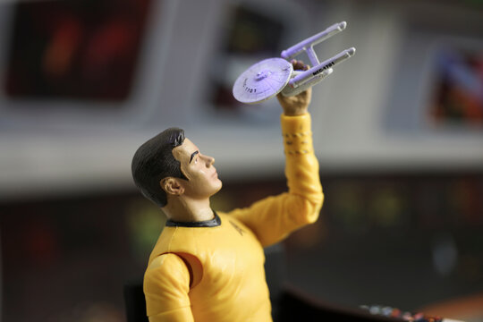 NEW YORK USA, JULY 11 2018: Star Trek Captain James T Kirk playing with a model USS Enterprise while sitting on the bridge - Art Asylum action figure