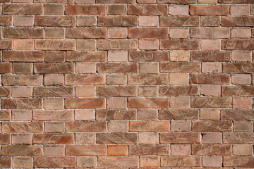 Brick wall textures create a pattern that extends horizontally and vertically along the wall. The shades of red, varied by time and wear, add depth and character to the composition.