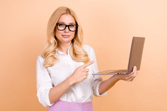 Portrait of blonde curls javascript developer programmer lady pointing finger new useful software isolated on beige color background.