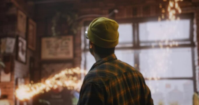 A Man In A Yellow Hat Is Standing In A Room With A Large Window Warehouse Photorealism Set Design