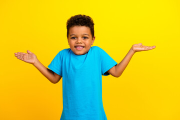 Photo of funky clueless child with curly hair dressed blue t-shirt shrug shoulders have no idea...
