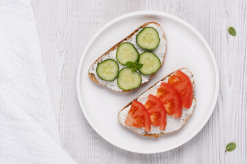 Healthy sandwiches with white cottage cheese, cucumber and tomato