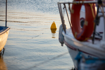Wooden boat on the water in the port. Fishing boat on the water at sunset. Close-up of a fishing boat.