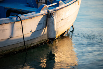 Wooden boat on the water in the port. Fishing boat on the water at sunset. Close-up of a fishing boat.