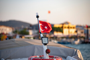 Flag of Turkey on a fishing boat in the port. Turkish flag on a boat in the sea. 