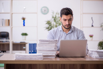 Young male employee and too much work in the office