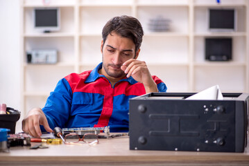 Young male repairman repairing computer