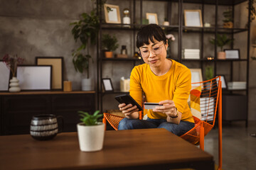 Japanese woman use credit card mobile phone online shopping at home