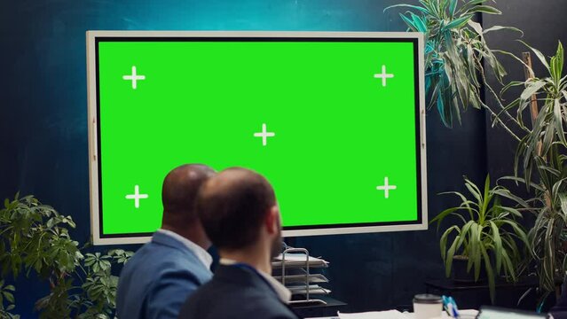 Startup team watching an ad campaign video on greenscreen display, examining the final promotional product to ensure sales growth. PR specialists collaborating on enterprise development. Camera A.