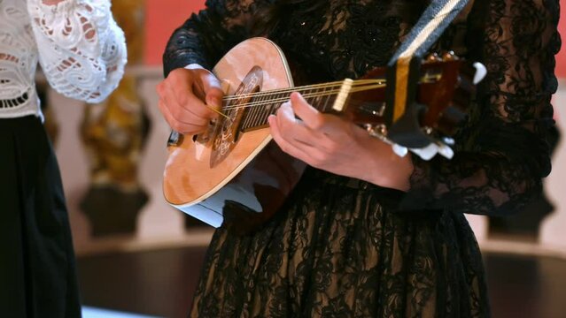 Close-up of two women playing the mandolin