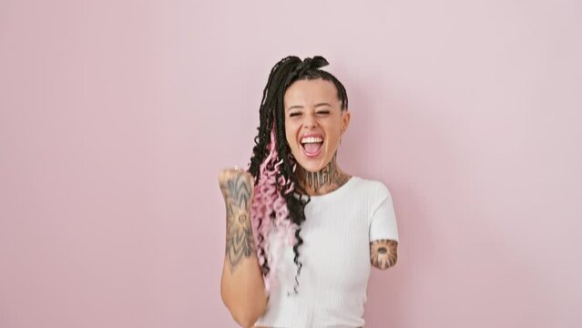 Thrilled armless hispanic woman cheering in victory! standing over a pink isolated background, she showcases her win with a soaring, excited scream of joy and success.