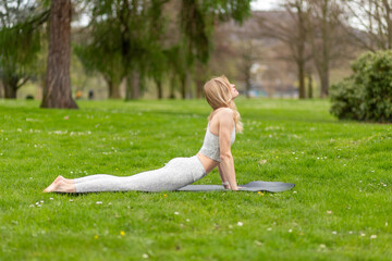 Woman doing yoga in park, cobra exercise