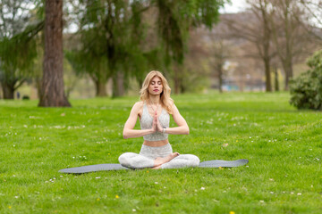 Woman in lotus pose meditating in park