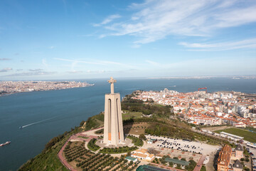 Portugal. Panoramic drone view of the Cristo Rei statue in Almada on sunny summer day. Giant monument Sanctuary of Christ the King in background city landscape and blue sky 