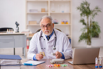 Old male doctor pharmacist in drugs synthesis concept - 782570606