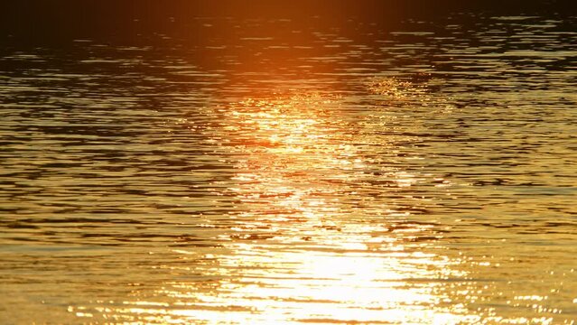 Reflection of sunlight like fire, sun set and golden hour over lake surface. Retreat spot for yoga and meditation.